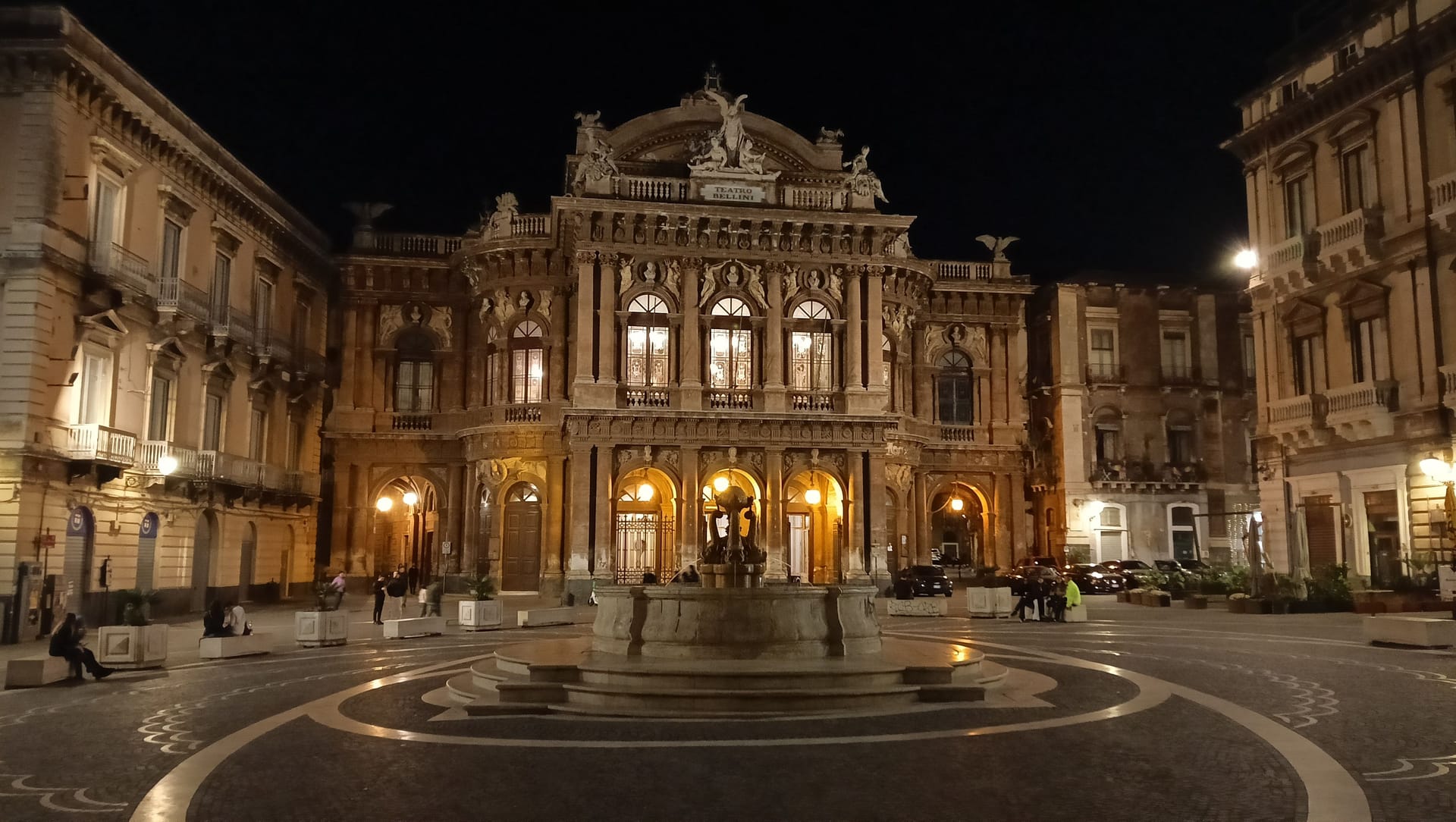 Il Teatro Massimo Bellini di Catania illuminato di notte, con la fontana al centro della piazza